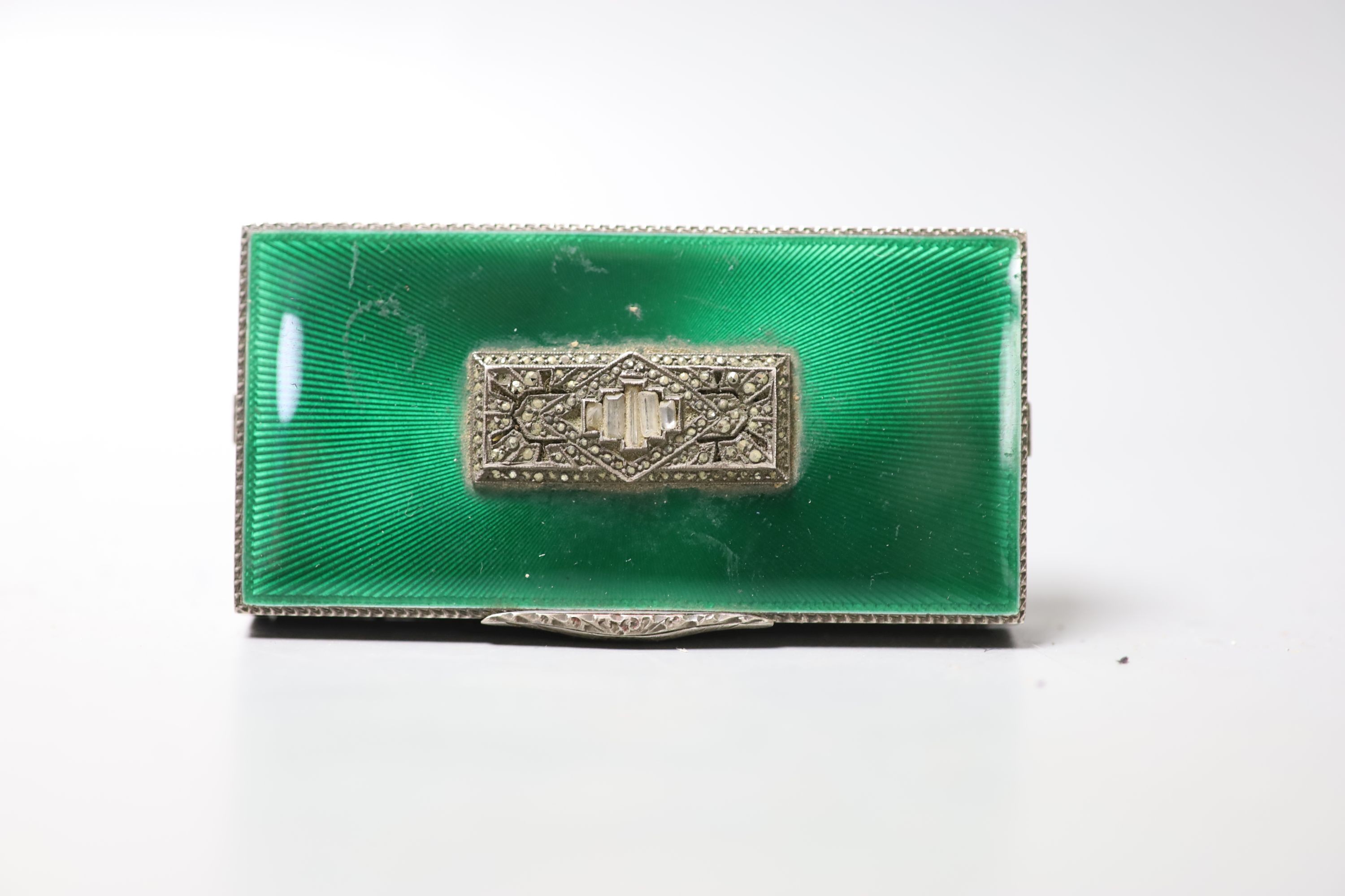 A 1930's engine turned silver, green enamel, marcasite and paste set minaudiere, lacking mirror and lipstick, import marks for George Stockwell, London, 1931, 8cm.